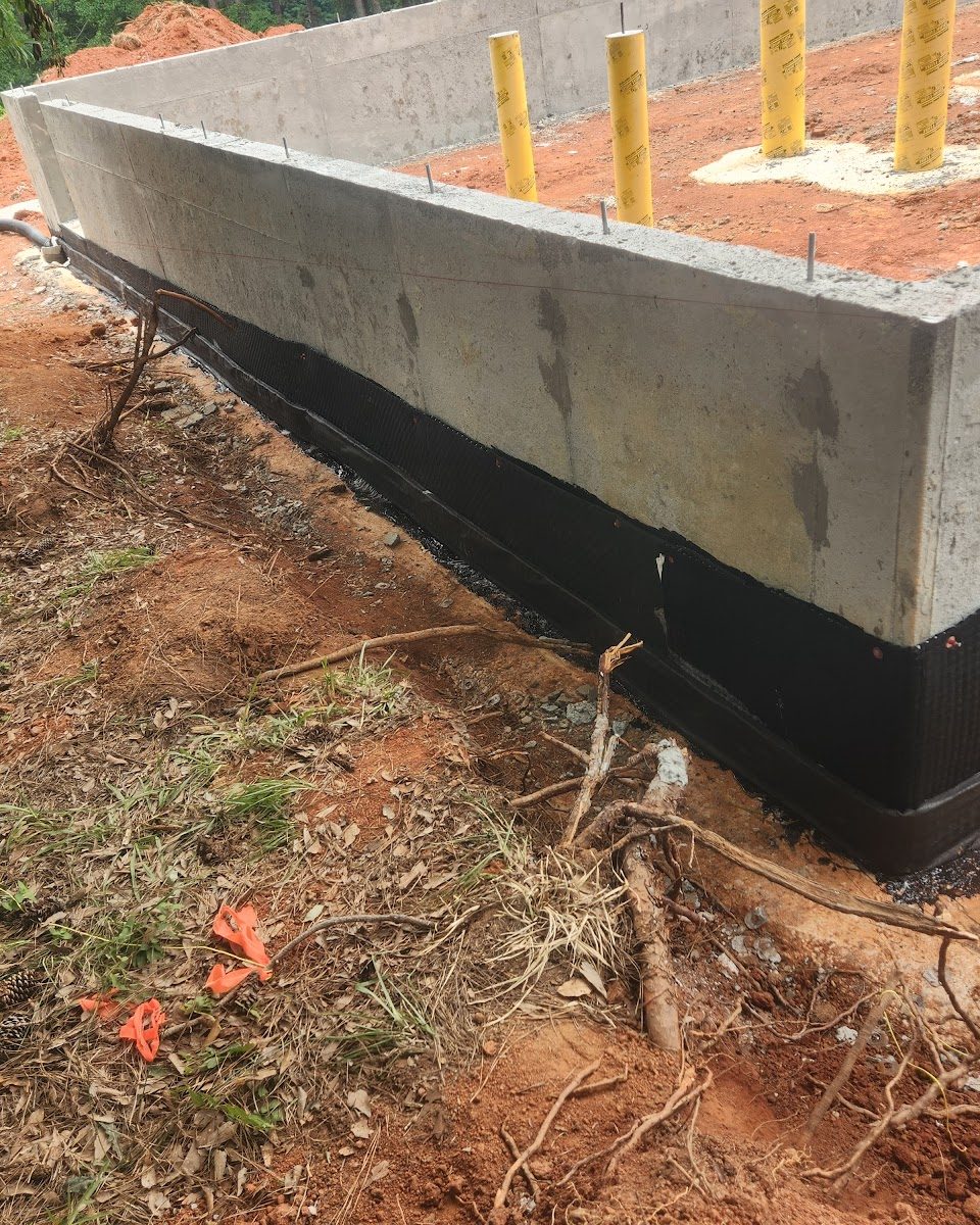 Foundation wall waterproofing membrane applied before backfill